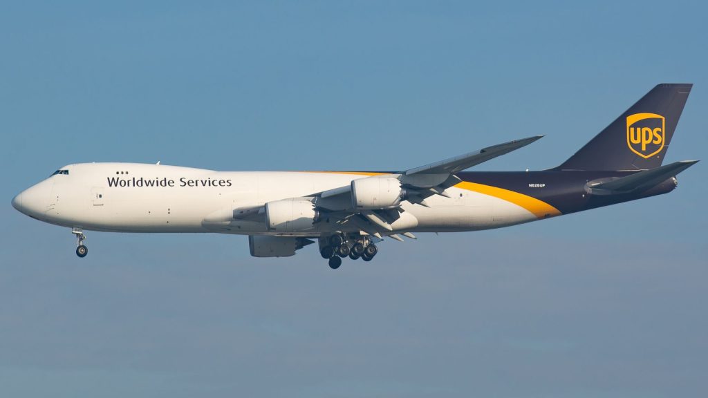 UPS cargo plane in flight against clear blue sky, showcasing delivery services. — 747 Live