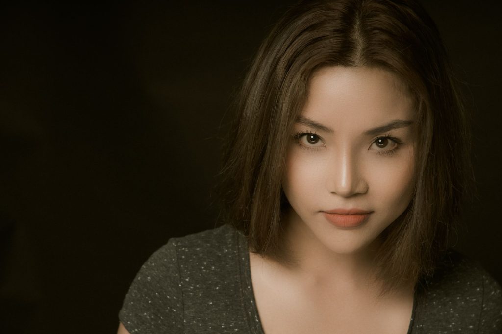 Stunning portrait of a woman with brown hair posing against a dark background, exuding confidence and beauty. — Aj Raval Scan