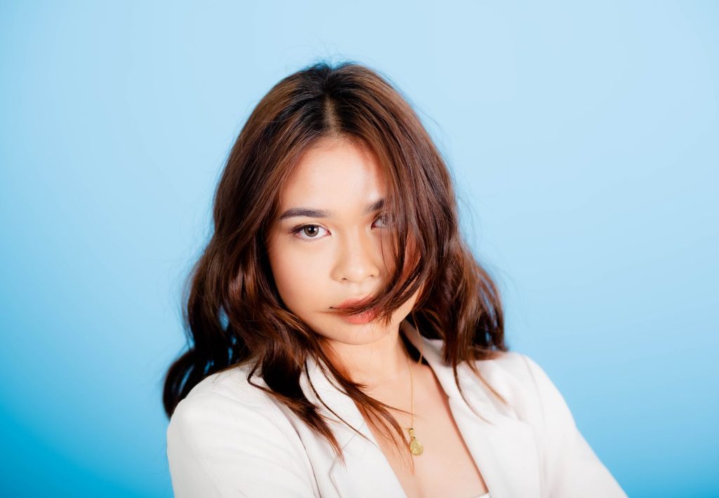 Portrait of a stylish young woman with wavy hair against a blue background. — Andrea Brillantes Scandal