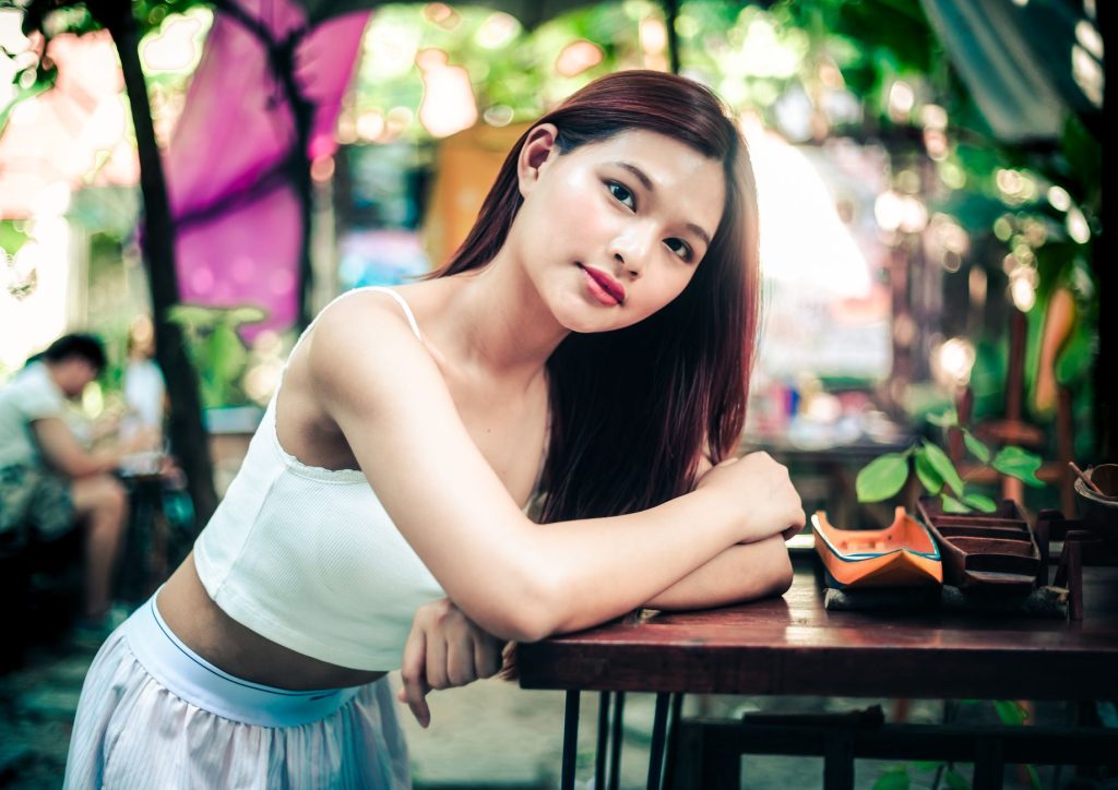 A serene outdoor portrait of a young woman relaxing in a garden setting. — Asian Pinay