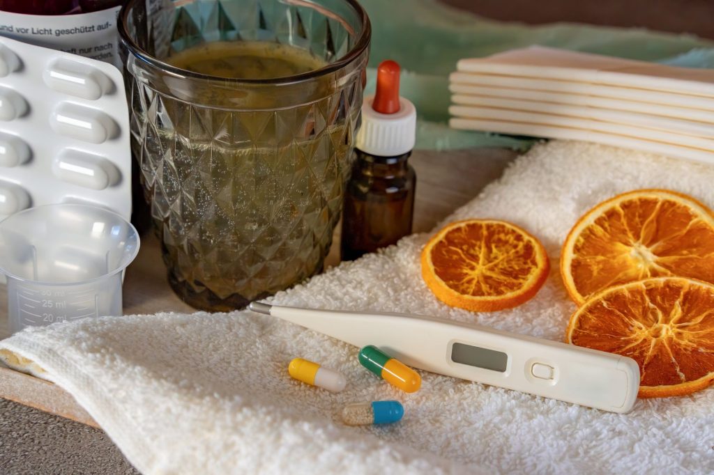 A flat lay of home remedies for cold and flu, featuring herbs and pharmaceuticals. — Bioflu