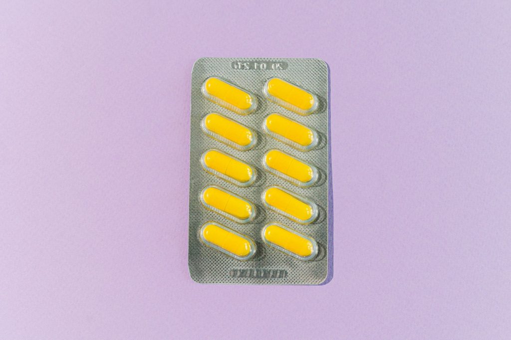 A blister pack of yellow pills on a purple background, symbolizing healthcare and medication. — Gamot Sa Ubo