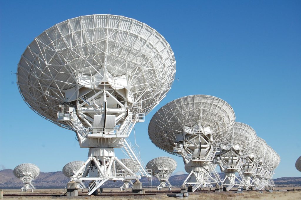 Array of radio telescopes at the Very Large Array in New Mexico under a clear blue sky. — Igsat