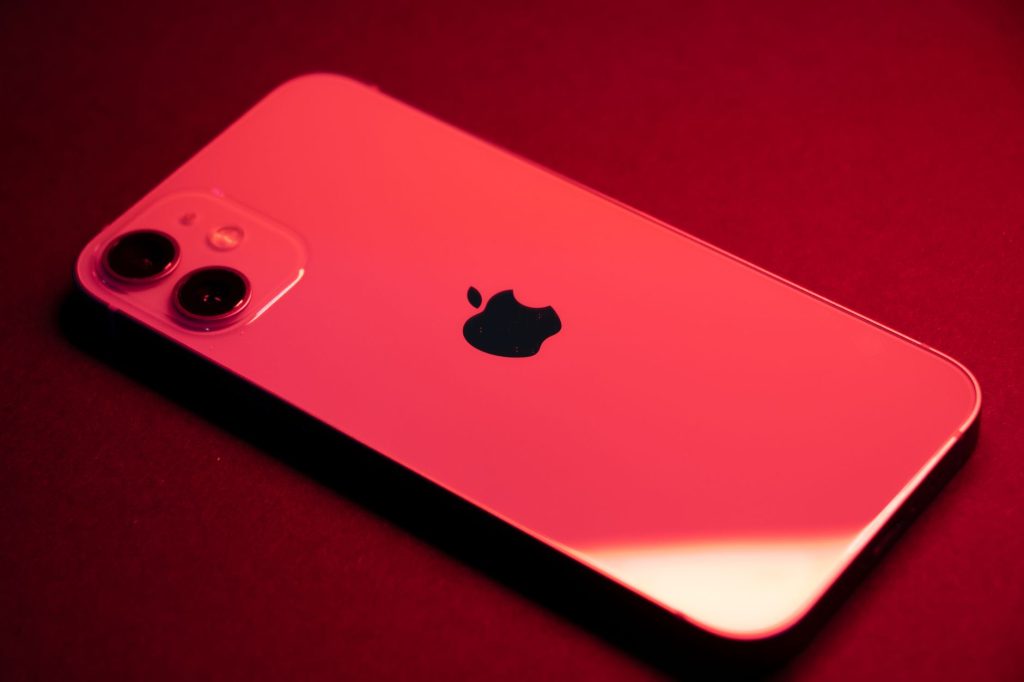 Close-up of a red smartphone with dual lenses on a red backdrop, highlighting sleek design and technology. — Iphone Xr Price