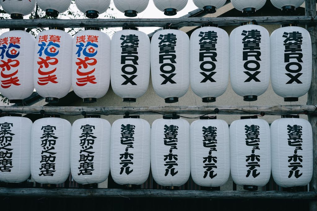 A display of traditional Japanese lanterns adorned with kanji writing, symbolizing cultural heritage. — Japanese To Tagalog