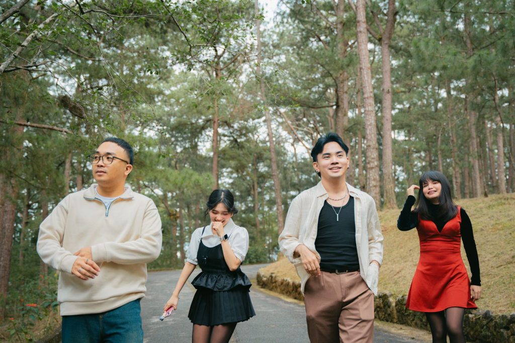 Four friends walking joyfully through a forest trail, enjoying a sunny day outdoors. — Paraluman Lyrics