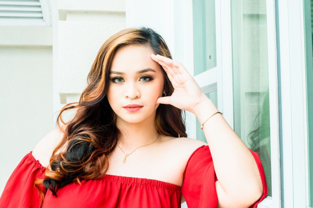 Stylish portrait of an Asian woman in a red off-shoulder top posing confidently. — Pinay Scandal Com