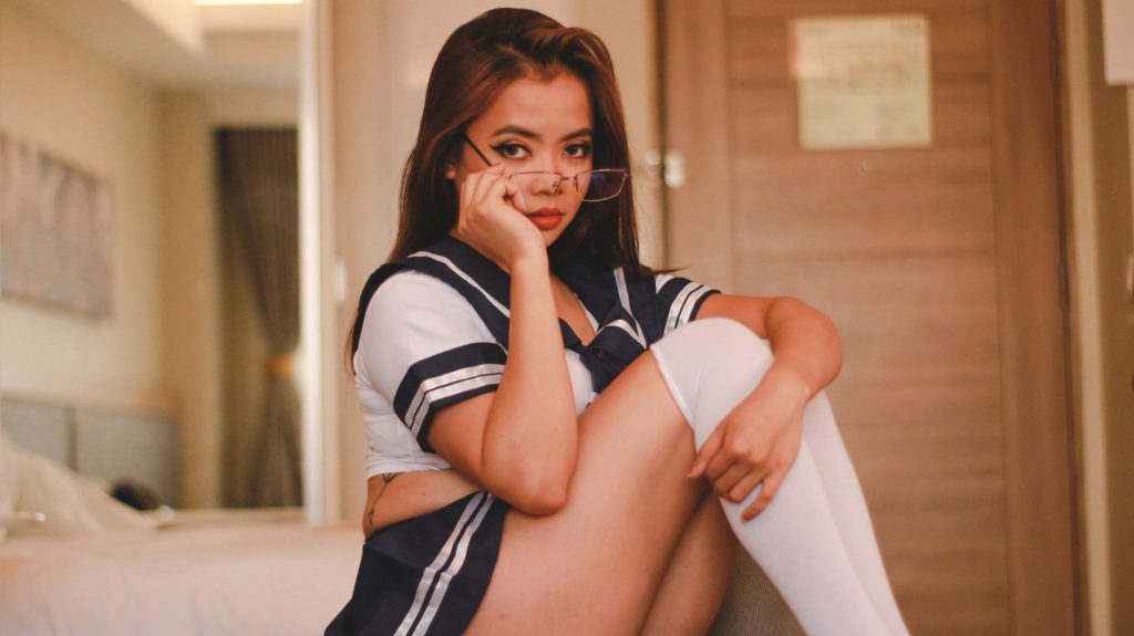 Model posing in a stylish school uniform cosplay indoors, showcasing fashion elegance. — Porb Hub