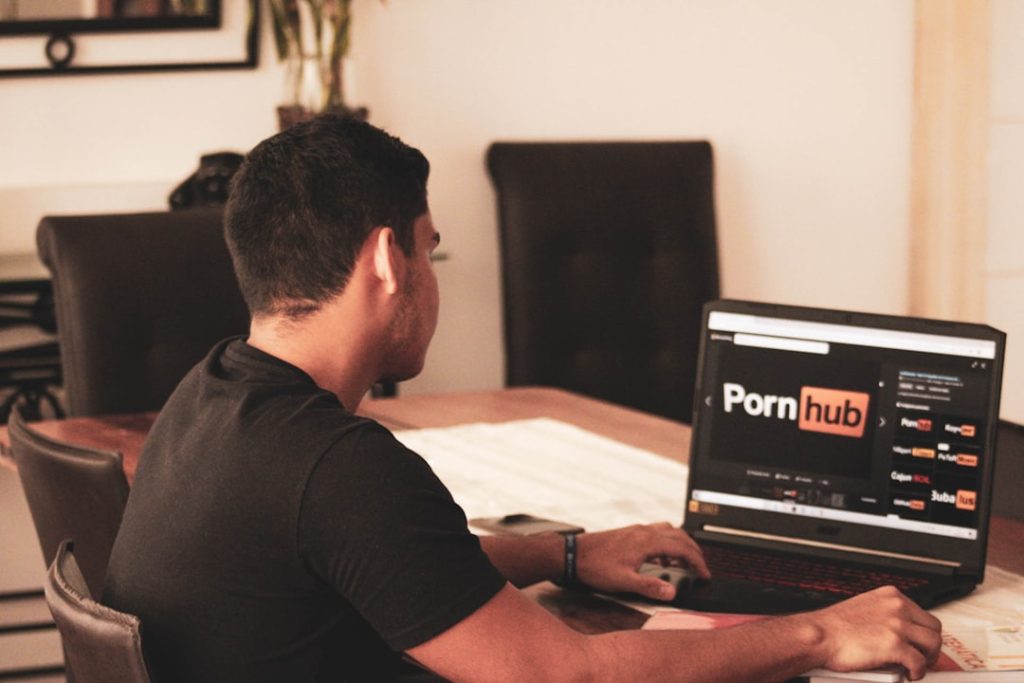 Man in black t-shirt using black laptop computer — Purnhub