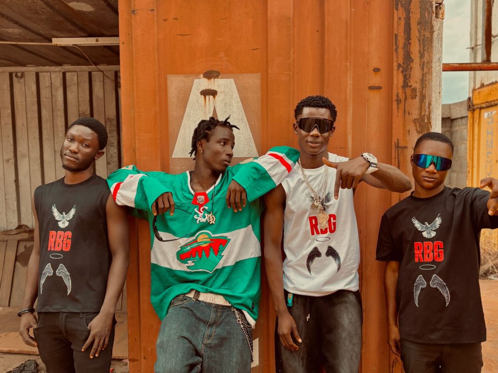 Four young adults showcase urban street style in a rustic setting. — Rbreezy