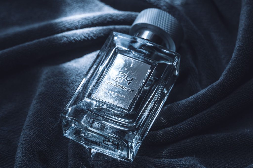 Luxurious glass perfume bottle on dark textured fabric, exuding elegance and refinement. — Rule 34 Ml