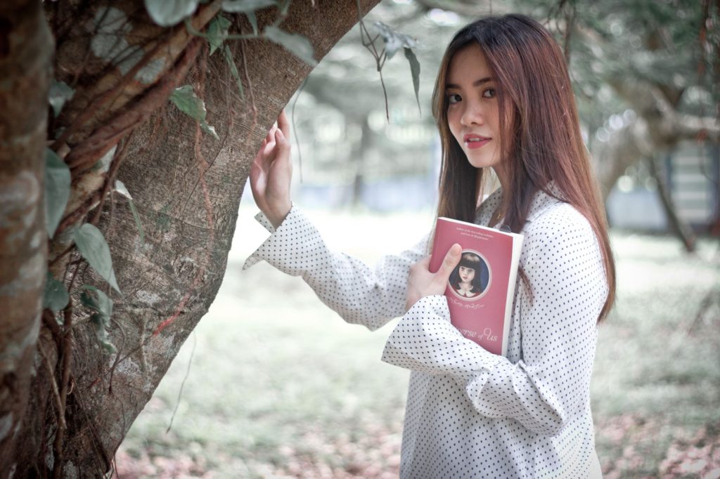 Asian woman enjoying a book and nature in Cavite City, Philippines. — Sarapbabe
