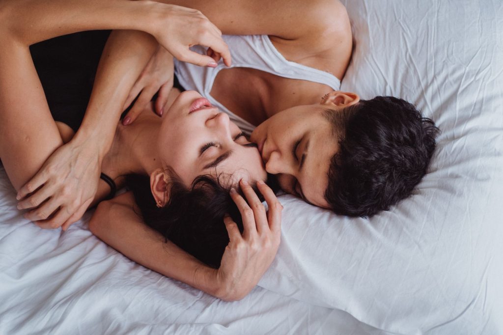 A close and tender moment of love between a non-binary couple lying together. — Sex Scandal