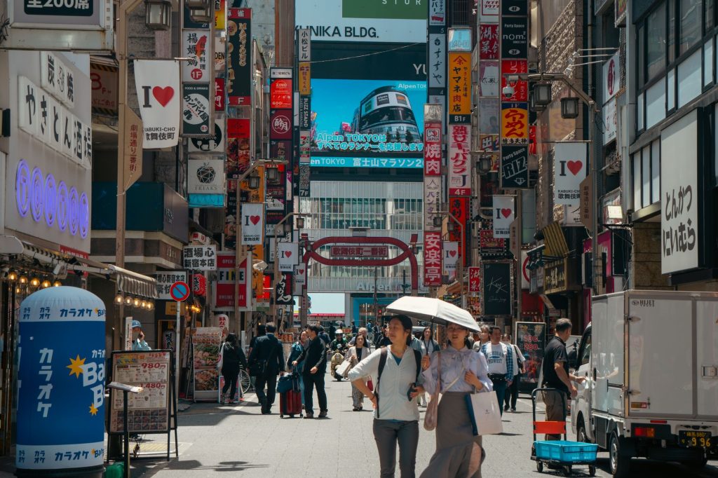 Busy daytime scene in bustling Shibuya, Tokyo with diverse crowd and signage. — Tagalog To Japanese