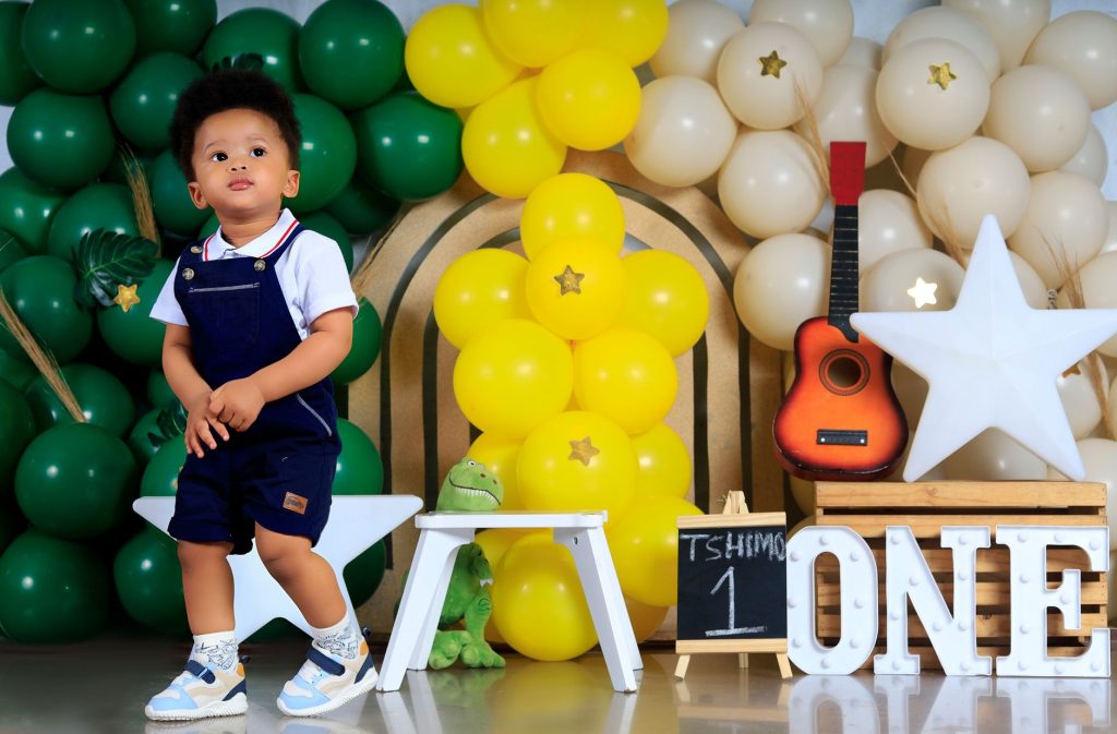 Adorable toddler at a vibrant first birthday party with colorful balloons and decorations. — Tmtplay